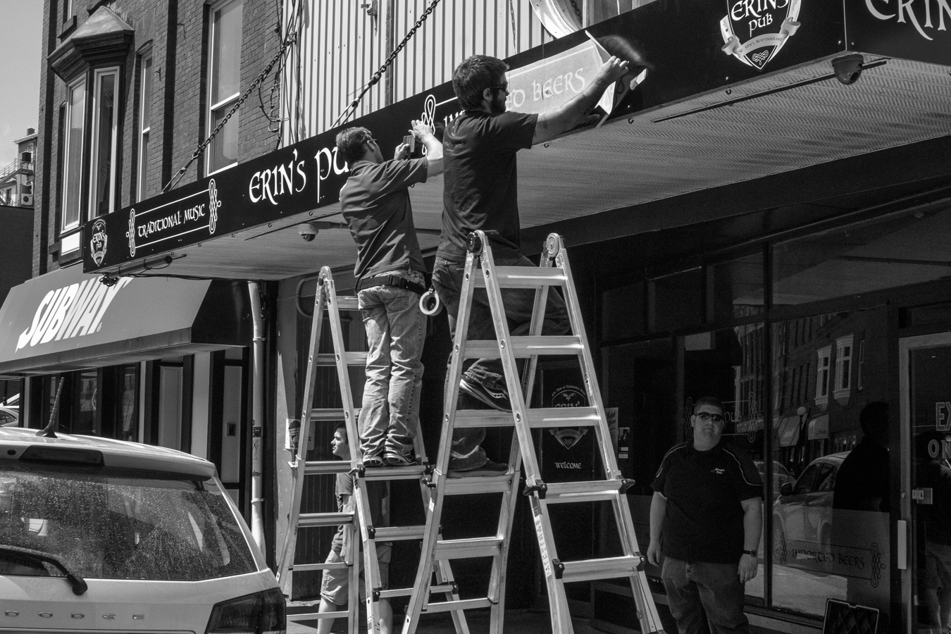 Sign workers installing new lettering. - Erins Pub - Water Street