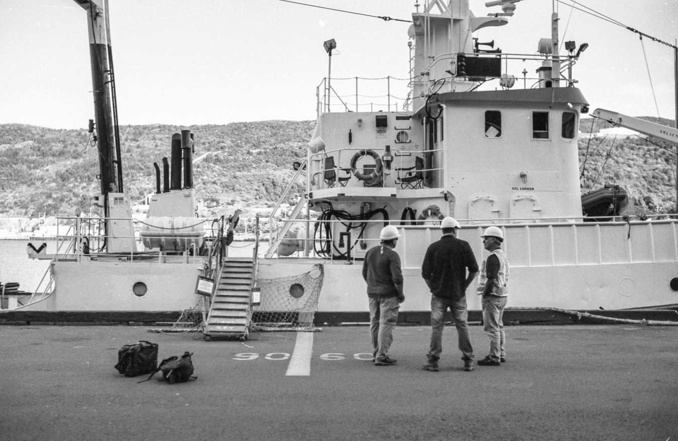 Gentlemen getting ready to board a ship in the harbour - harbour apron